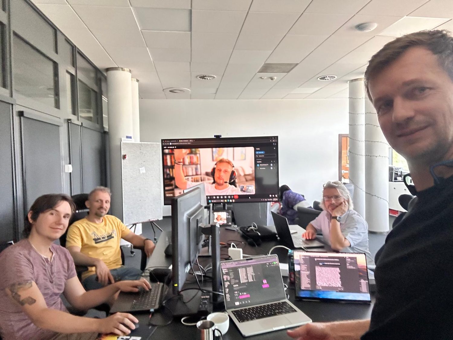 The ARTOS team during the GenJam match, laptops and a video call on the big screen.